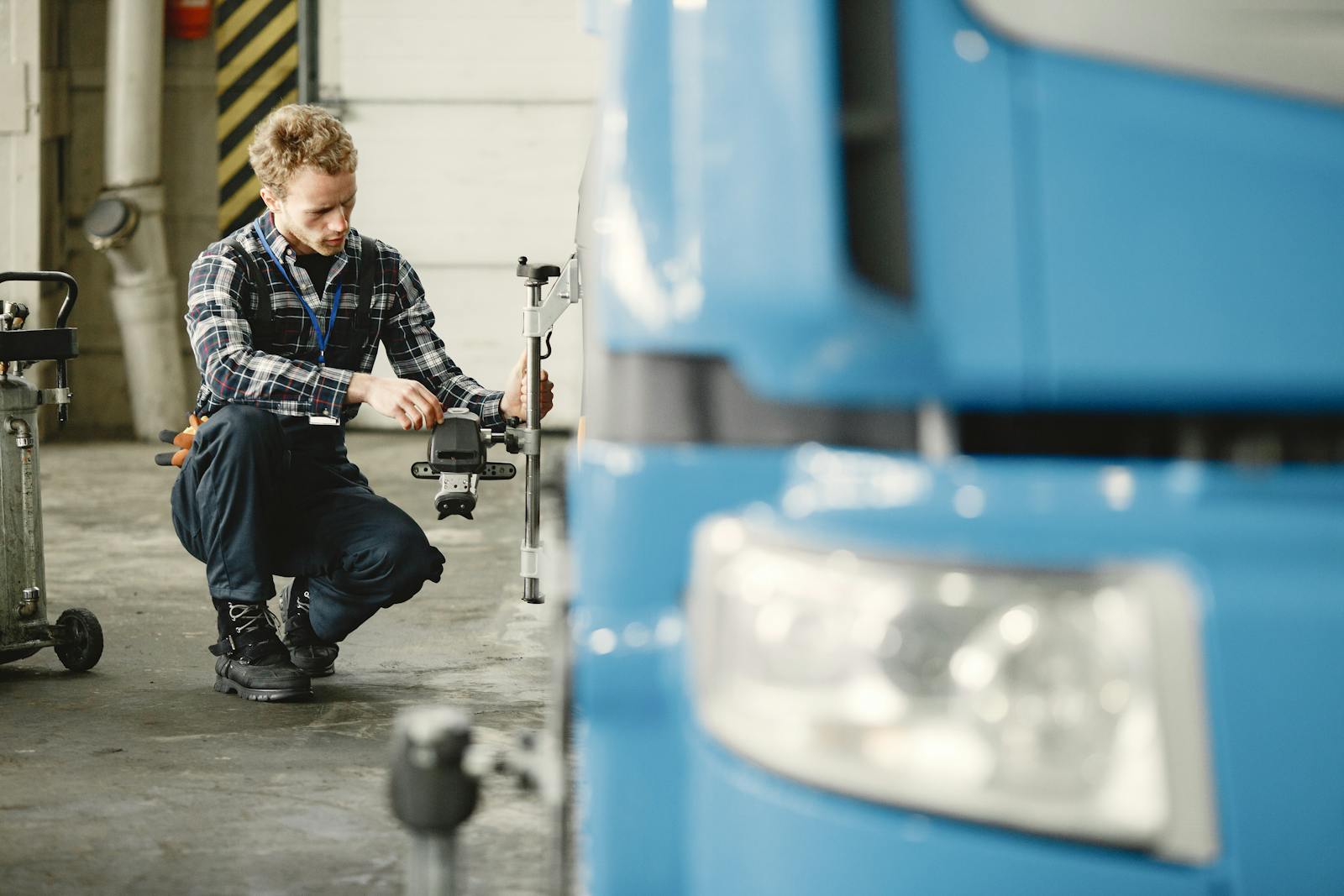Mechanic aligning wheels of a truck in a workshop setting, highlighting precision and skill.